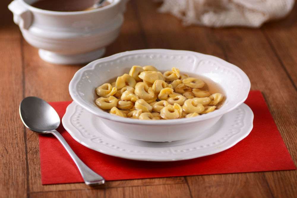 Tortellini are served on a set table, a traditional dish who Italian families eat during the holidays.
